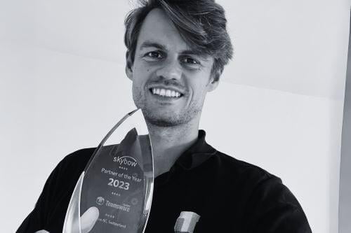 Leon Lüneborg hält den Award zum Partner des Jahres 2023 in den Händen